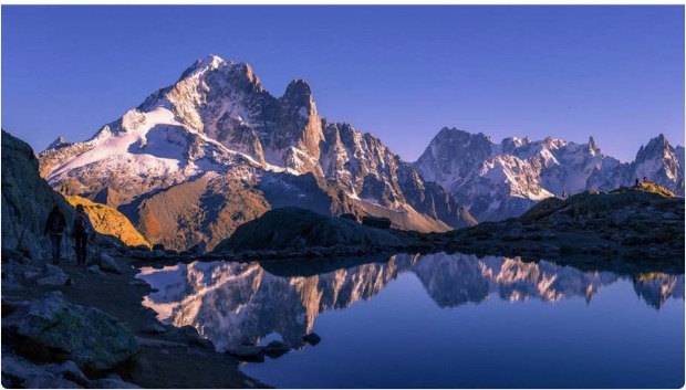 登山者在夕阳下的山顶剪影